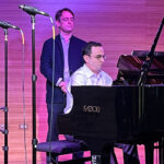 Patrick Zimmeli observes rehearsals as Ian Gindes performs at the piano.