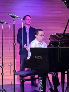 Patrick Zimmeli observes rehearsals as Ian Gindes performs at the piano.