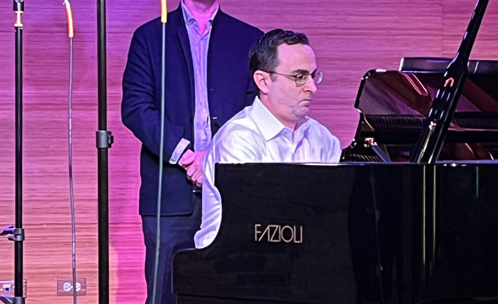 Patrick Zimmeli observes rehearsals as Ian Gindes performs at the piano.